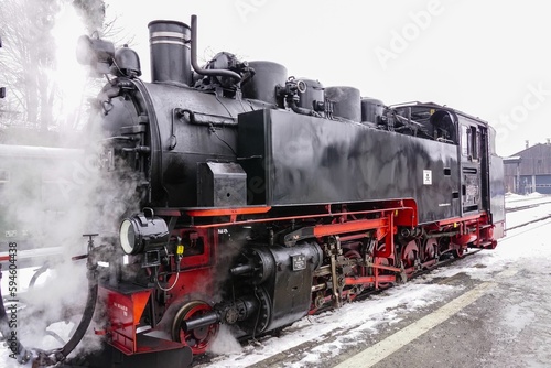 an old fashioned steam engine is traveling down the train tracks