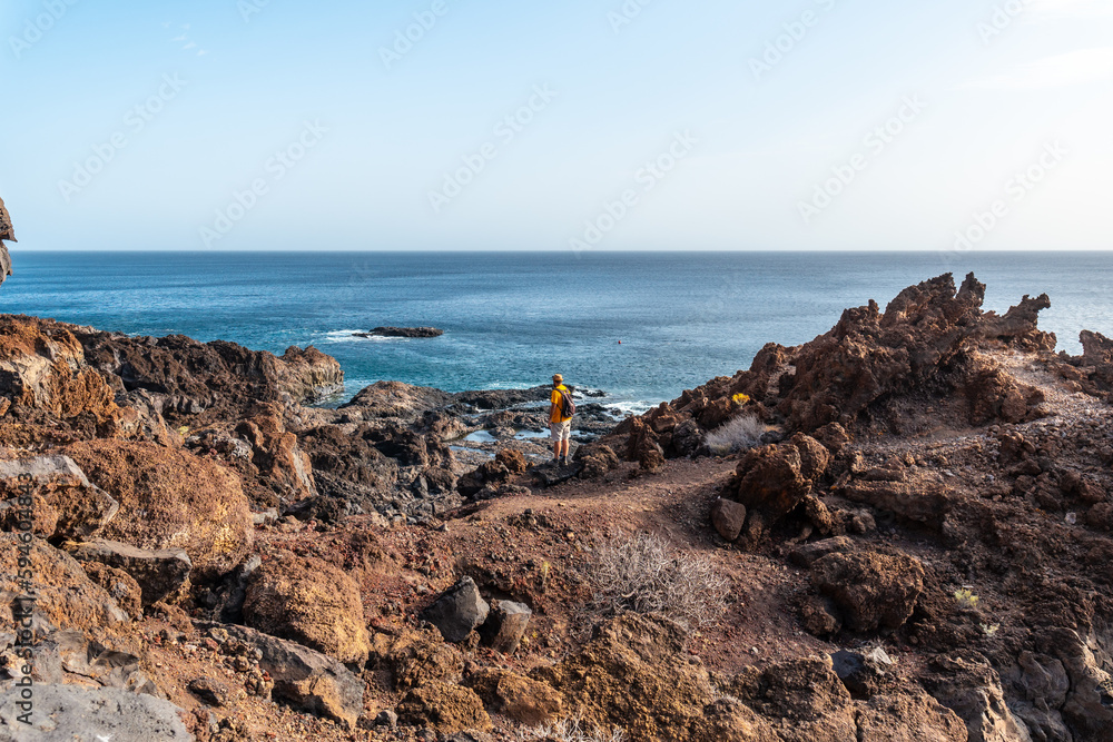 Tourist enjoying the landscape on a volcanic trail on the beach of Tacoron on El Hierro, Canary Islands