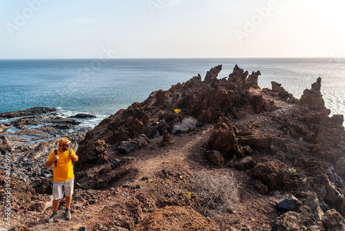 Tourist walking on a volcanic path on the beach of Tacoron on El Hierro, Canary Islands photo