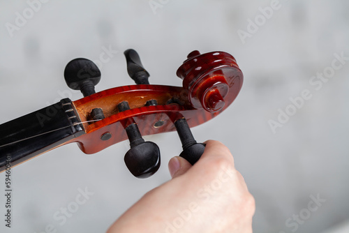 Cuadro en lienzo Violin on studio background. String stretching process.