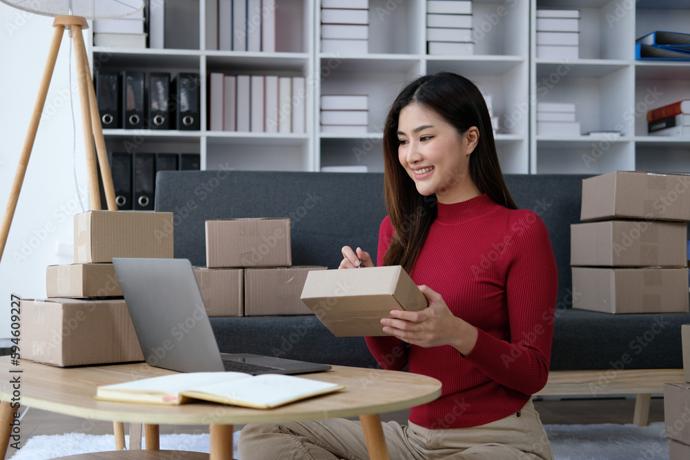 Startup small business entrepreneur of freelance Asian woman using a laptop with box Cheerful success online marketing packaging box and delivery SME idea concept Startup small business entrepreneur of freelance Asian woman using a laptop with box Cheerful success online marketing packaging box and delivery SME idea concept