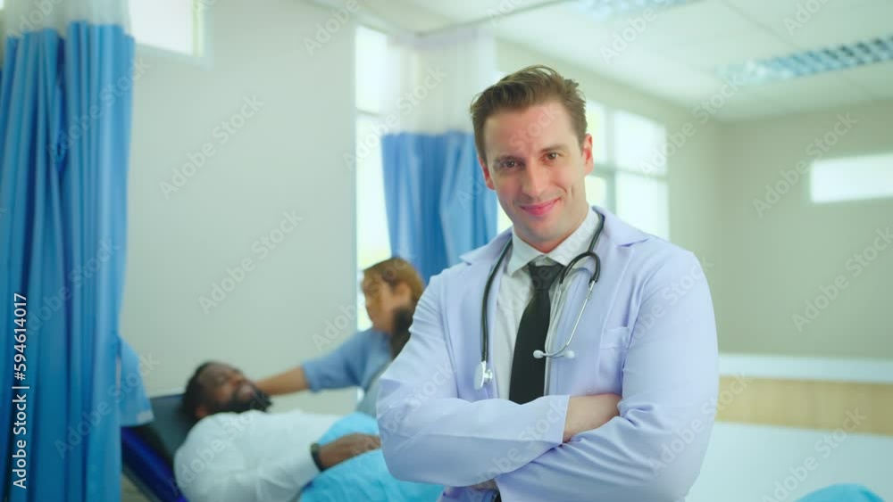 Portrait of male doctor looking to camera and smile feel happy.  Background patient in hospital room. Positive general practitioner close up face portrait.