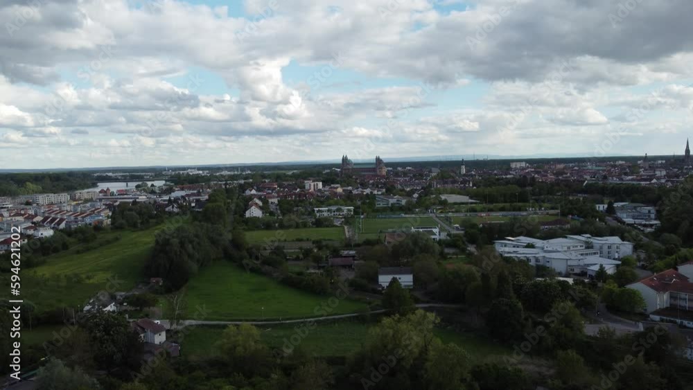 Drone shot of a green landscape with river and houses in the background under blue cloudy sky Drone shot of a green landscape with river and houses in the background under blue cloudy sky