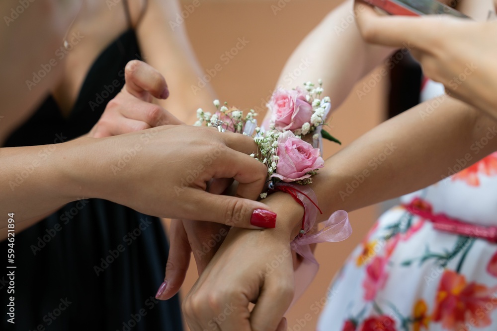 Women wearing bracelets adorned with flowers on a wedding Women wearing bracelets adorned with flowers on a wedding