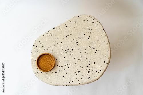 Top view of an abstract stone coffee table with a wooden coaster on top