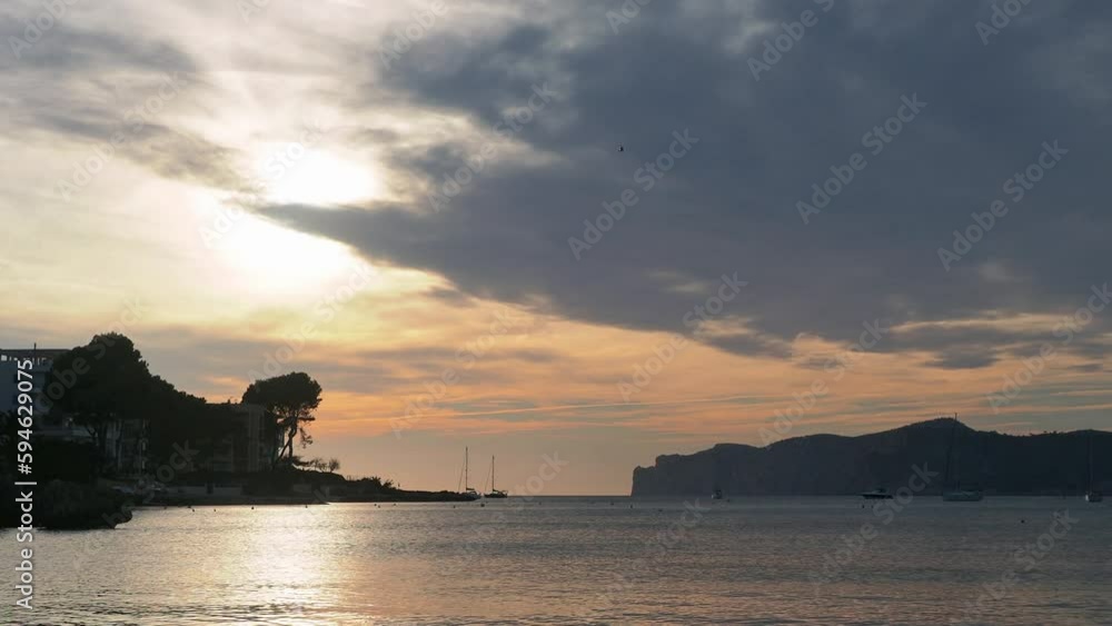 A helicopter crosses the sky in this beautiful sunset over the sea.