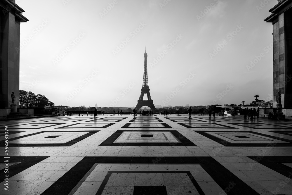 Eiffel Tower, French: Tour Eiffel, silhouette at dawn. View from Trocadero Square with geometrical marble pavement. Paris, France. Black and white photography.