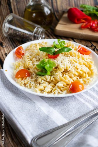 Macaroni with cheese and vegetables. On a wooden background