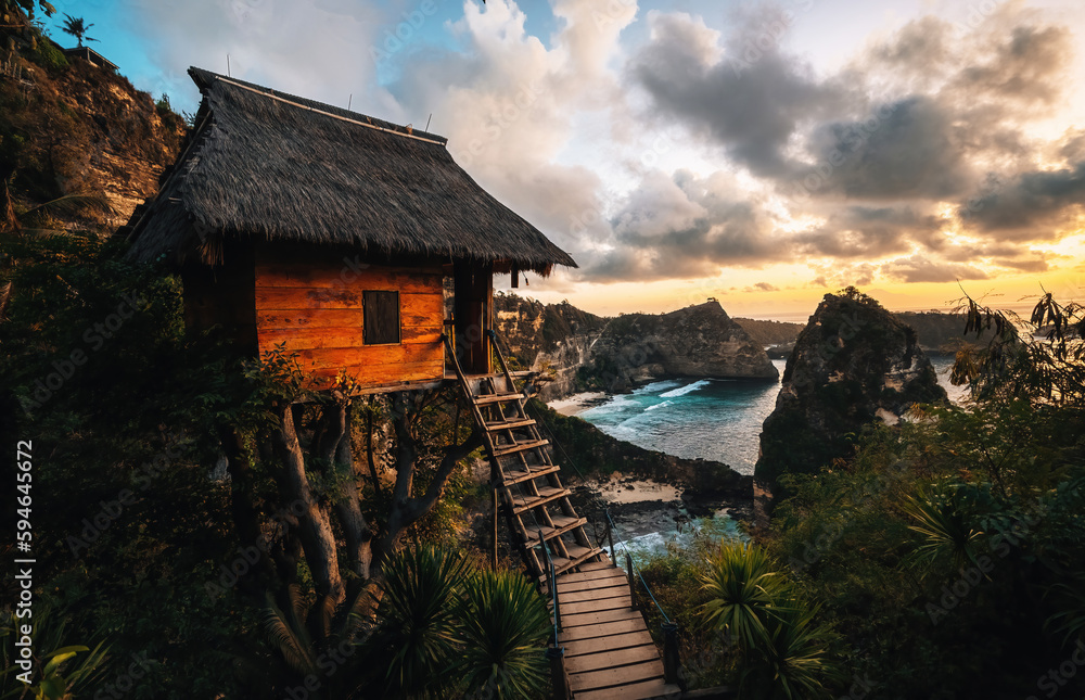 Tree house and Diamond beach in Nusa penida island, Bali in Indonesia. Sunrise with warm colors. Tree house and Diamond beach in Nusa penida island, Bali in Indonesia. Sunrise with warm colors.