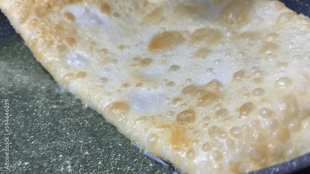 Pasties cheburek with meat fried in sunflower oil, deep fry. Crimean Tatar fast food, traditional food. Dough in a pan with hot oil Pasties cheburek with meat fried in sunflower oil, deep fry. Crimean Tatar fast food, traditional food. Dough in a pan with hot oil