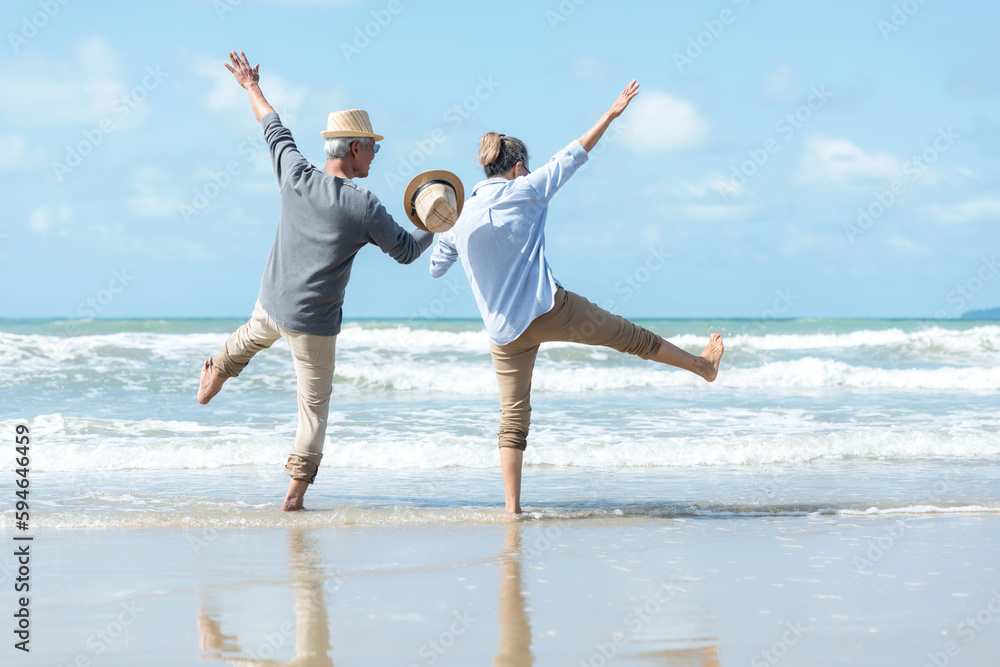 Asian Lifestyle senior couple walking chill and jumping on the beach happy in love romantic and relax time after retirement.  People tourism elderly family travel leisure and activity after retirement - obrazy, fototapety, plakaty 