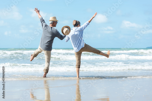Fotografija Asian Lifestyle senior couple walking chill and jumping on the beach happy in love romantic and relax time after retirement