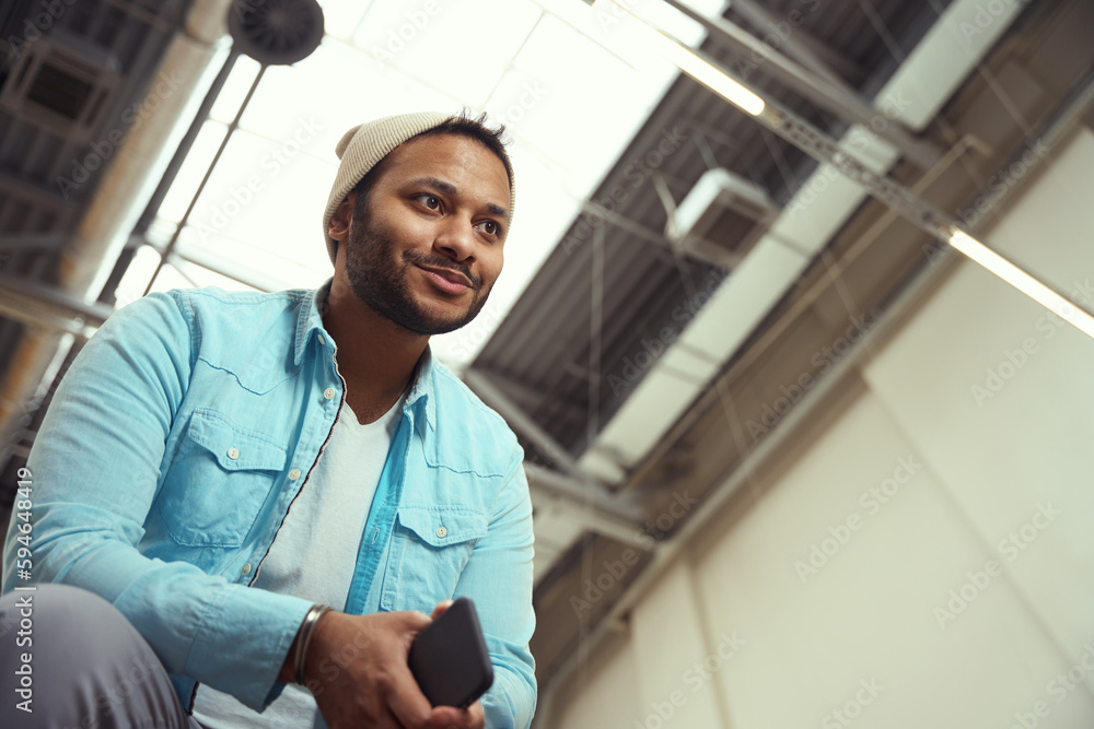 Young male in hat holding on smartphone Young male in hat holding on smartphone