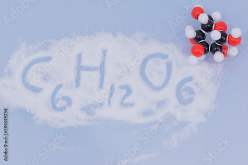Isolated glucose molecule made by molecular model with glucose formula written on white sugar. C6H12O6 sugar chemical formula with colored atoms and bonds photo