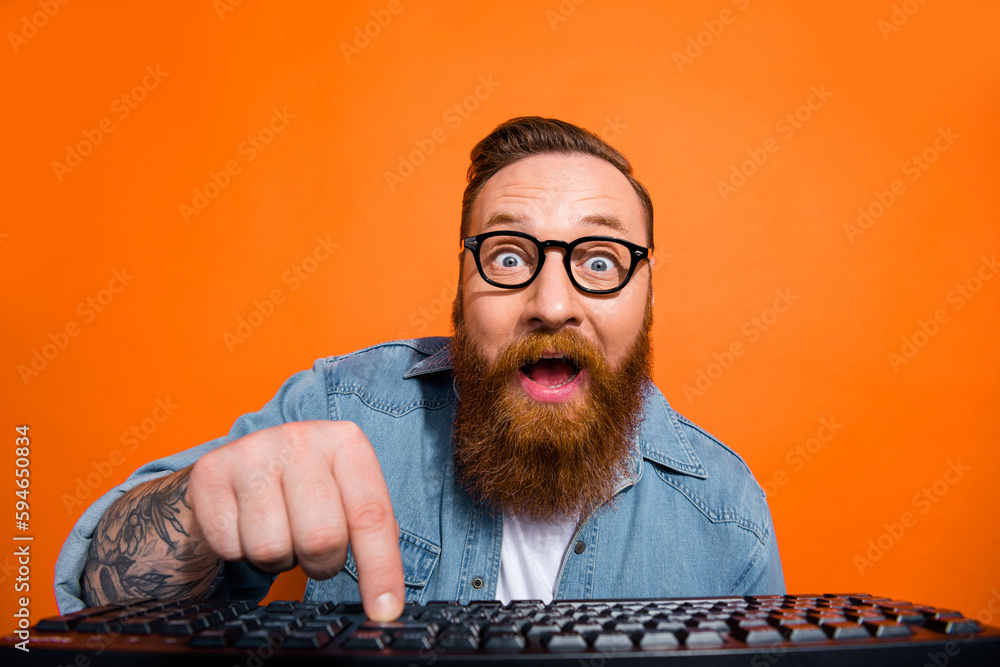 Closeup photo of excited funny businessman try launch his first ecommerce product wear glasses click keyboard isolated on orange color background - obrazy, fototapety, plakaty 
