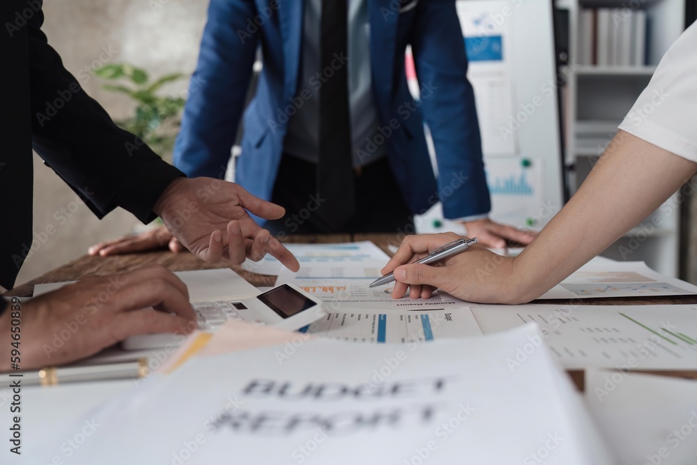 Business team using a calculator to calculate the numbers of statistic business profits growth rate on documents analyzing graph data, desk in the office Business team using a calculator to calculate the numbers of statistic business profits growth rate on documents analyzing graph data, desk in the office