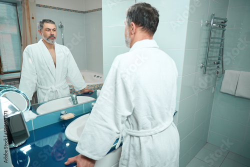 Man morning routine near the mirror in apartment