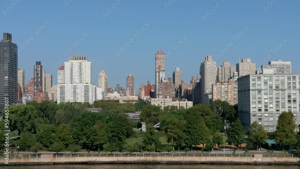 Drone shot of city skyline with a river and trees on a sunny day Drone shot of city skyline with a river and trees on a sunny day