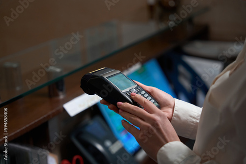 Administrator holding in hands and checking payment terminal