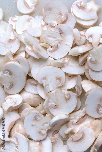 Sliced champignon mushrooms close up. Healthy food ingredient concept. Cooking background. Selective focus