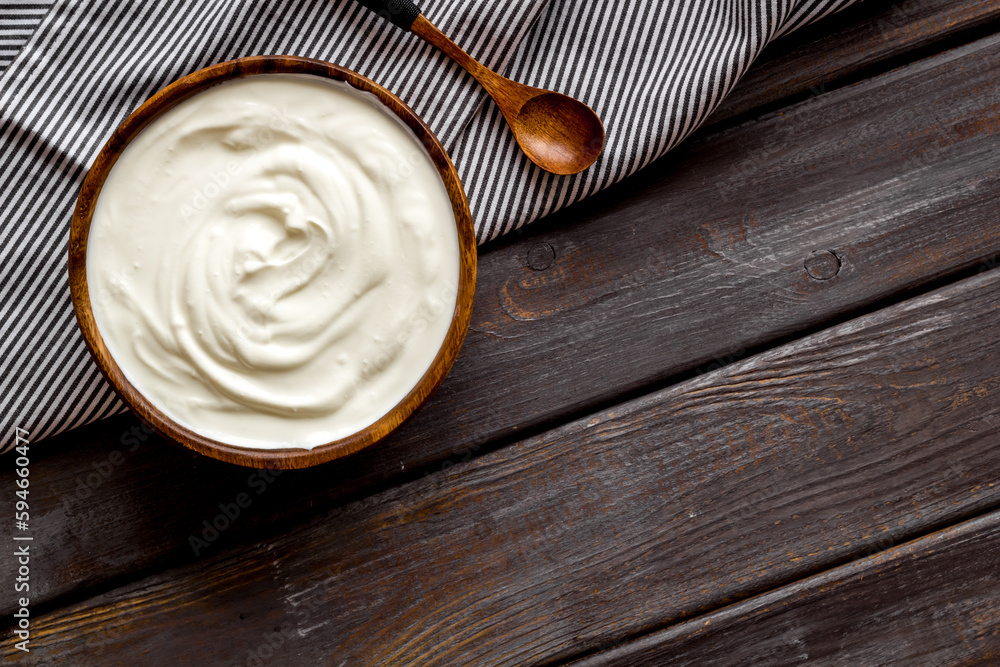 White sauce sour cream or yogurt in wooden bowl, top view White sauce sour cream or yogurt in wooden bowl, top view