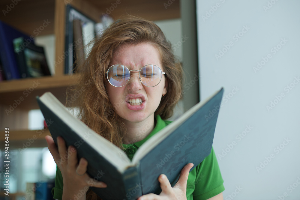 Portrait of tired overworked, exhausted young woman in glasses college or university student is study hard in library, prepare to exam, lesson Portrait of tired overworked, exhausted young woman in glasses college or university student is study hard in library, prepare to exam, lesson