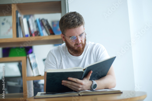 Portrait of serious concentrated guy, young man in glasses college or university student is study hard in library, prepare to exam, lesson