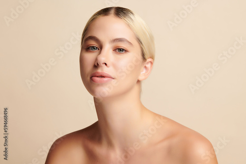 Beautiful young woman with clean fresh skin on beige background, Face care, Facial treatment, Cosmetology, beauty and spa,