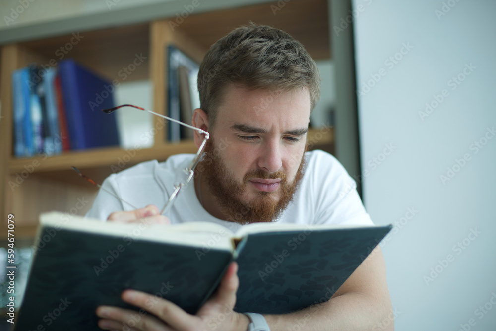 tired overworked guy, exhausted young man in glasses college or university student is study hard in library, lesson, problem with eyes, myopic purblind. Vision eyes problems, myopia, blindness. tired overworked guy, exhausted young man in glasses college or university student is study hard in library, lesson, problem with eyes, myopic purblind. Vision eyes problems, myopia, blindness.