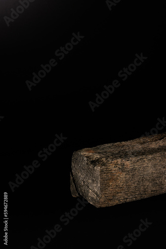 Trozo de madera antigua en fondo negro ideal para exhibir productos cosméticos, alimenticios y otros / Piece of old wood on a black background ideal for displaying cosmetic, food and other products.