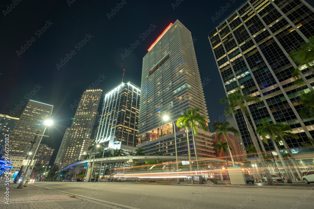 Night urban landscape of downtown district of Miami Brickell in Florida USA. Illuminated high skyscraper buildings and street with car trails and Metrorail traffic in modern american megapolis Night urban landscape of downtown district of Miami Brickell in Florida USA. Illuminated high skyscraper buildings and street with car trails and Metrorail traffic in modern american megapolis