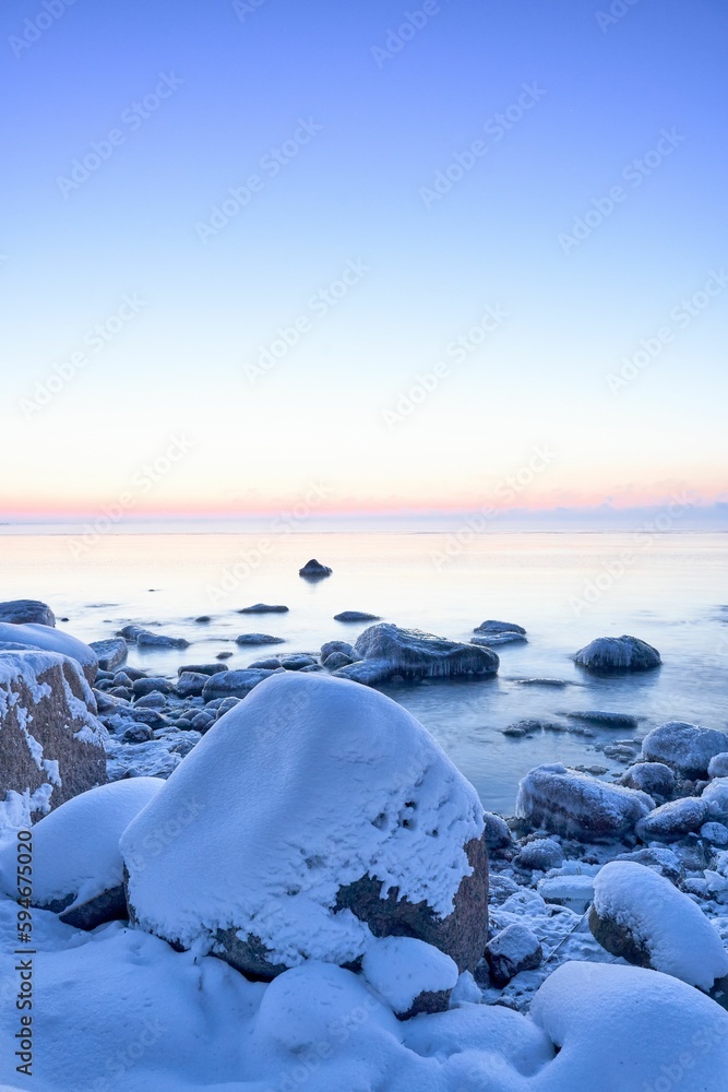 Tranquil winter scene with a picturesque skyline reflecting off of the snow-covered rocks below Tranquil winter scene with a picturesque skyline reflecting off of the snow-covered rocks below