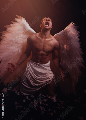 Young strong angel with white wings from heaven. Angel with muscular body. Sensual man
