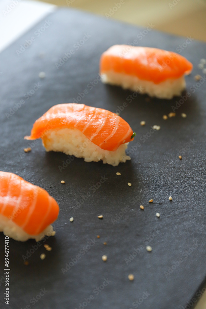 close up of nigiri sushis on dark tray close up of nigiri sushis on dark tray