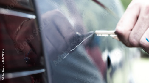 Картината върху платно Man scratching car paint with a key, vandalism