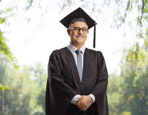 University dean wearing a black graduation gown and posing outdoors photo