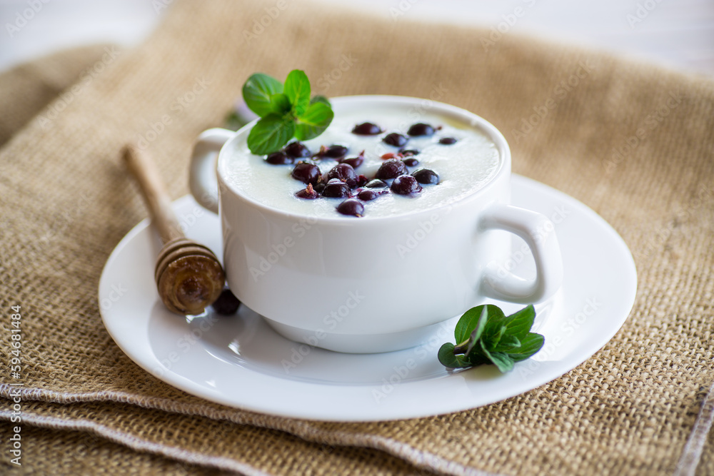 Cooked milk semolina porridge with berries and honey in a plate.