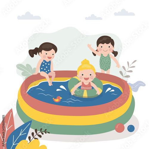 Happy girls playing and swim in small inflatable pool. Summer time, active game in water. Preschool kids in swimsuits. Childhood, entertainment. Sport, active games.