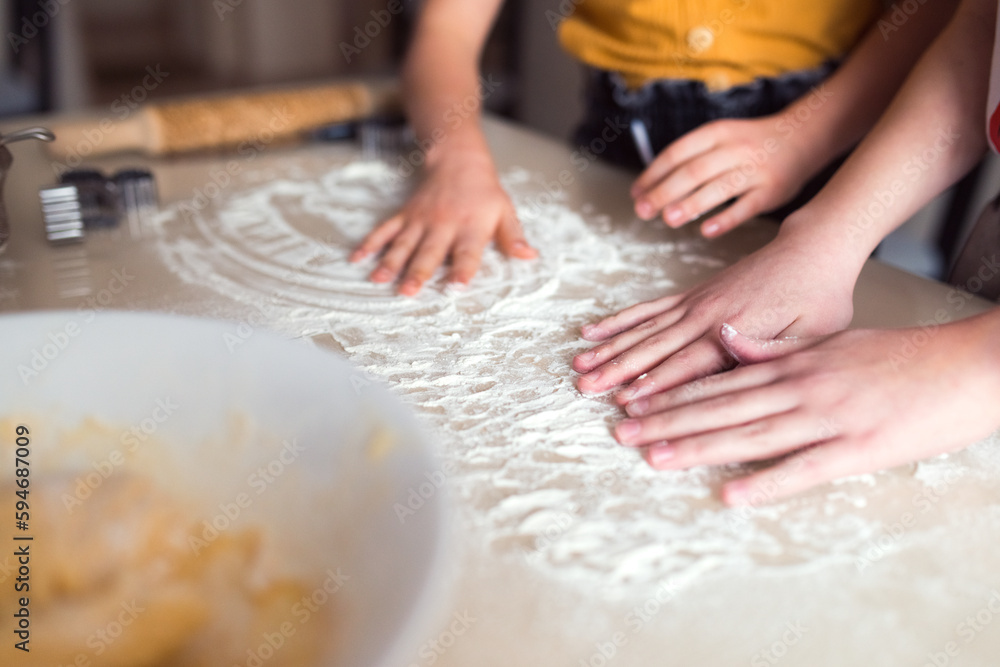 Fototapeta premium Making cookies at home, two girls cooking together, using modeling splinter