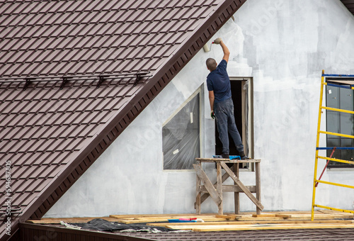 Workers are priming outside the walls of the house.