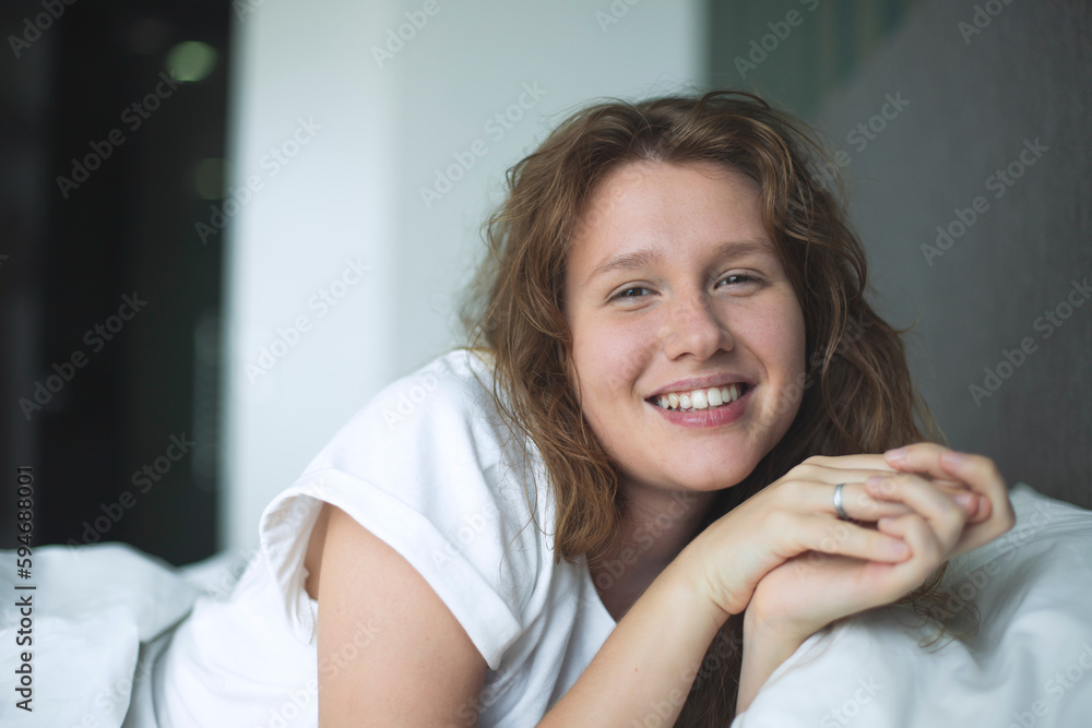 Young happy beautiful sleepy woman in the bed in bedroom at home in the morning lying under white blanket, enjoy resting, sleep well, wake up and smile. Good morning Young happy beautiful sleepy woman in the bed in bedroom at home in the morning lying under white blanket, enjoy resting, sleep well, wake up and smile. Good morning
