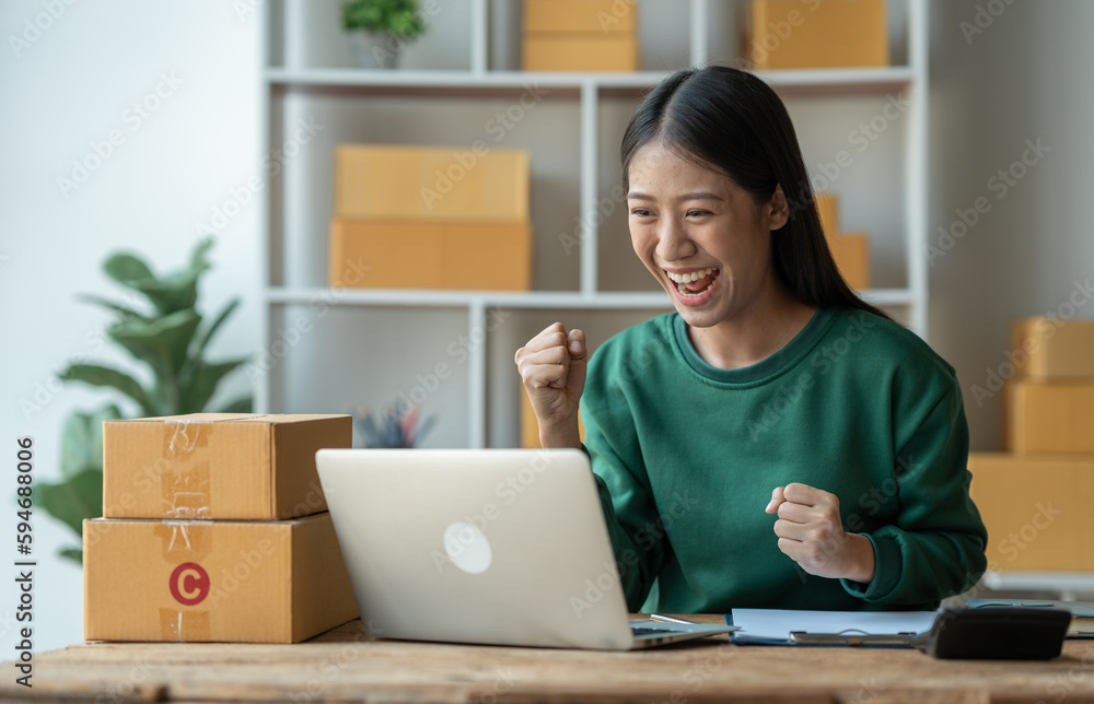 Asian female startup business owner She smiled and was delighted to receive an online order from a customer showing her information on her laptop to prepare parcels for delivery through the company. Asian female startup business owner She smiled and was delighted to receive an online order from a customer showing her information on her laptop to prepare parcels for delivery through the company.