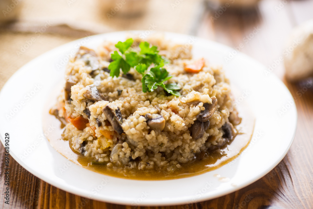 cooked bulgur with mushrooms, carrots and vegetables in a plate cooked bulgur with mushrooms, carrots and vegetables in a plate