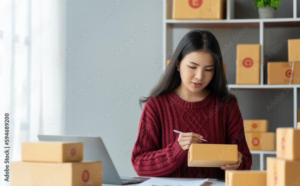Online business ideas Asian businesswoman holding parcel boxes preparing to deliver to customers with joy. Online business ideas Asian businesswoman holding parcel boxes preparing to deliver to customers with joy.