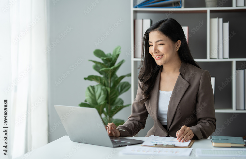 Asian businesswoman, online freelancer, confident investor working at laptop computer and pointing to graph showing financial growth. e-commerce management concept marketing. Asian businesswoman, online freelancer, confident investor working at laptop computer and pointing to graph showing financial growth. e-commerce management concept marketing.