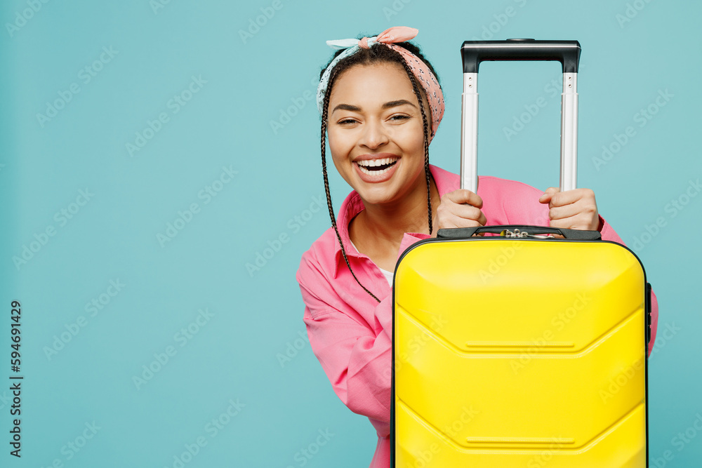 Traveler happy woman wear pink casual clothes hold suitcase isolated on plain light blue cyan background studio. Tourist travel abroad in free spare time rest getaway. Air flight trip journey concept. Traveler happy woman wear pink casual clothes hold suitcase isolated on plain light blue cyan background studio. Tourist travel abroad in free spare time rest getaway. Air flight trip journey concept.