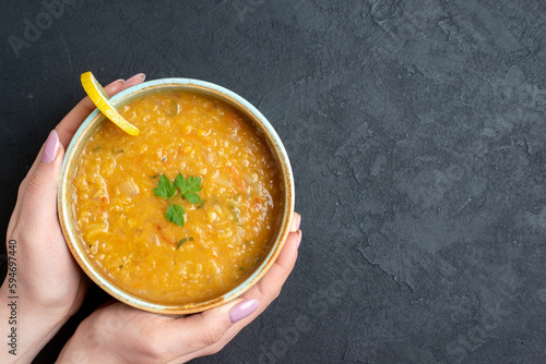 top view delicious lentil soup with female whos holding plate on a dark surface food diner colourful meal dish horizontal photo