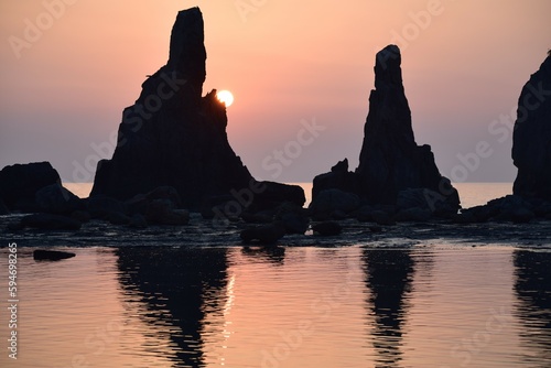 早朝の海岸に立つ奇岩