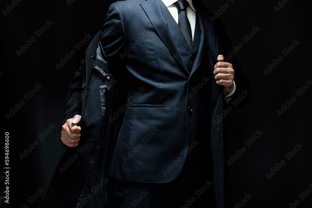 スーツの上にコートを着た男性