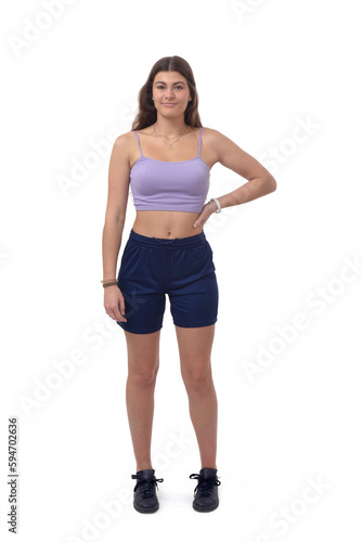 front view of a young girl standing with arm akimbo and looking at camera on white background